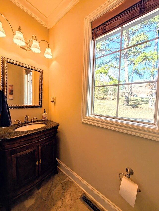 bathroom with ornamental molding, vanity, and baseboards