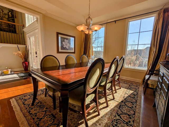 dining room with baseboards, plenty of natural light, wood finished floors, and a notable chandelier