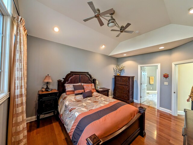 bedroom featuring lofted ceiling, baseboards, wood finished floors, and recessed lighting