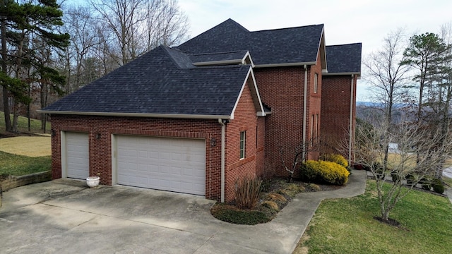 view of home's exterior featuring a garage, brick siding, concrete driveway, roof with shingles, and a lawn