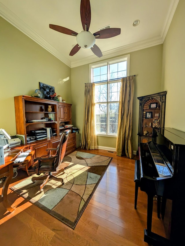 office area featuring ceiling fan, baseboards, crown molding, and wood finished floors