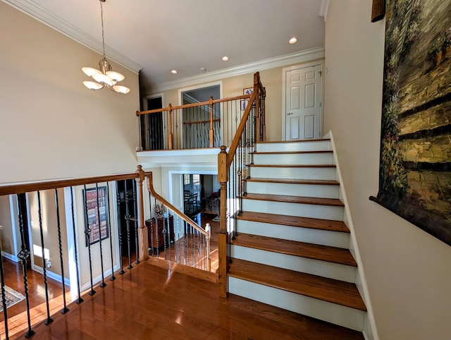 stairway featuring recessed lighting, wood finished floors, baseboards, ornamental molding, and an inviting chandelier