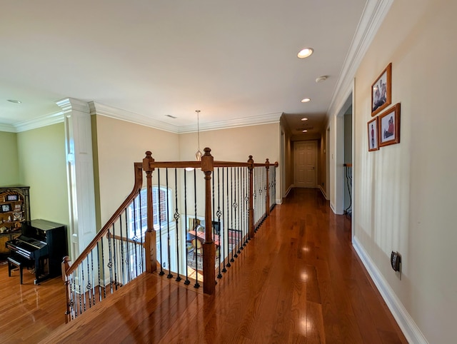 corridor featuring ornamental molding, wood finished floors, an upstairs landing, and baseboards