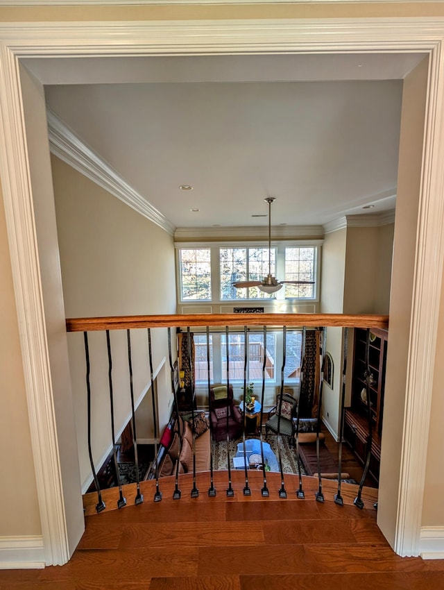 hallway featuring crown molding, baseboards, and wood finished floors