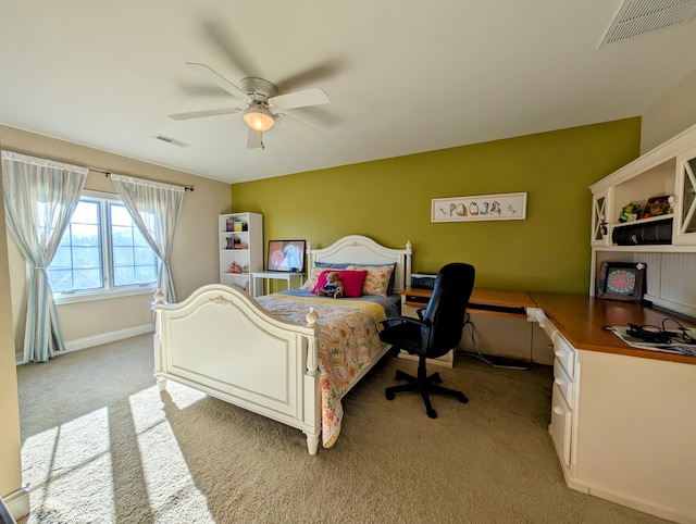 bedroom featuring ceiling fan, built in study area, visible vents, and light colored carpet