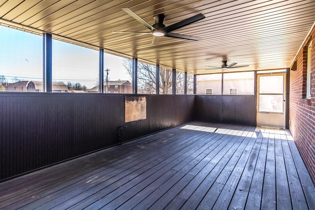 unfurnished sunroom featuring plenty of natural light and a ceiling fan