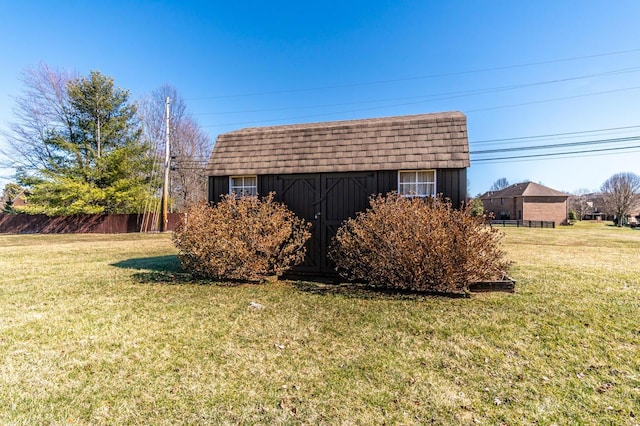 exterior space with a storage shed, fence, a lawn, and an outbuilding