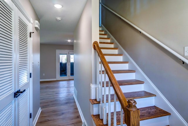 staircase with wood finished floors and baseboards