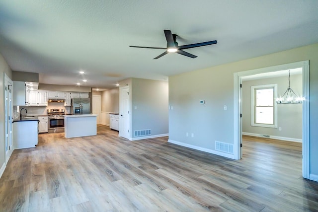 kitchen featuring open floor plan, appliances with stainless steel finishes, visible vents, and under cabinet range hood