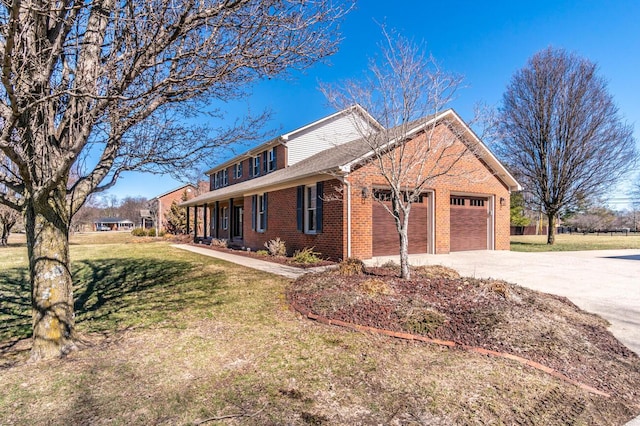 view of front of house with a garage, concrete driveway, brick siding, and a front yard