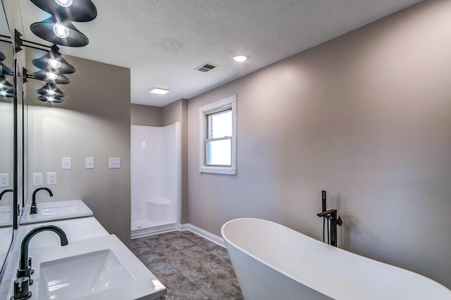 full bathroom featuring a textured ceiling, visible vents, walk in shower, and a sink