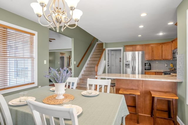 dining room featuring stairs, a notable chandelier, wood finished floors, and recessed lighting