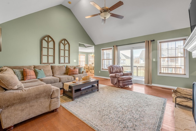 living area with high vaulted ceiling, a ceiling fan, baseboards, and wood finished floors