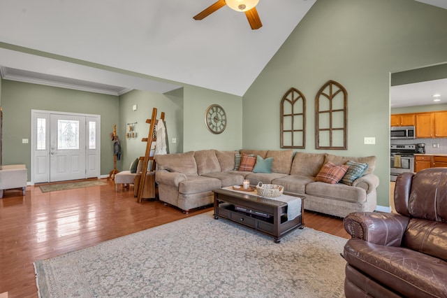 living room featuring high vaulted ceiling, ceiling fan, baseboards, and wood finished floors