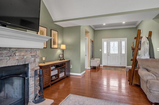 entrance foyer featuring baseboards, ornamental molding, wood finished floors, a stone fireplace, and recessed lighting