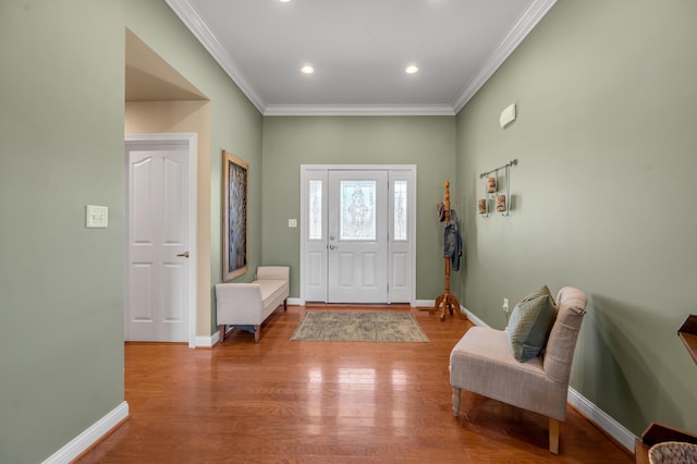 foyer entrance featuring crown molding, baseboards, wood finished floors, and recessed lighting