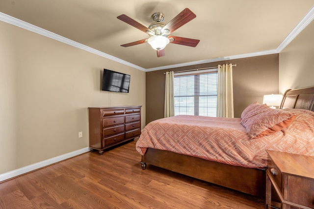 bedroom with ornamental molding, a ceiling fan, baseboards, and wood finished floors