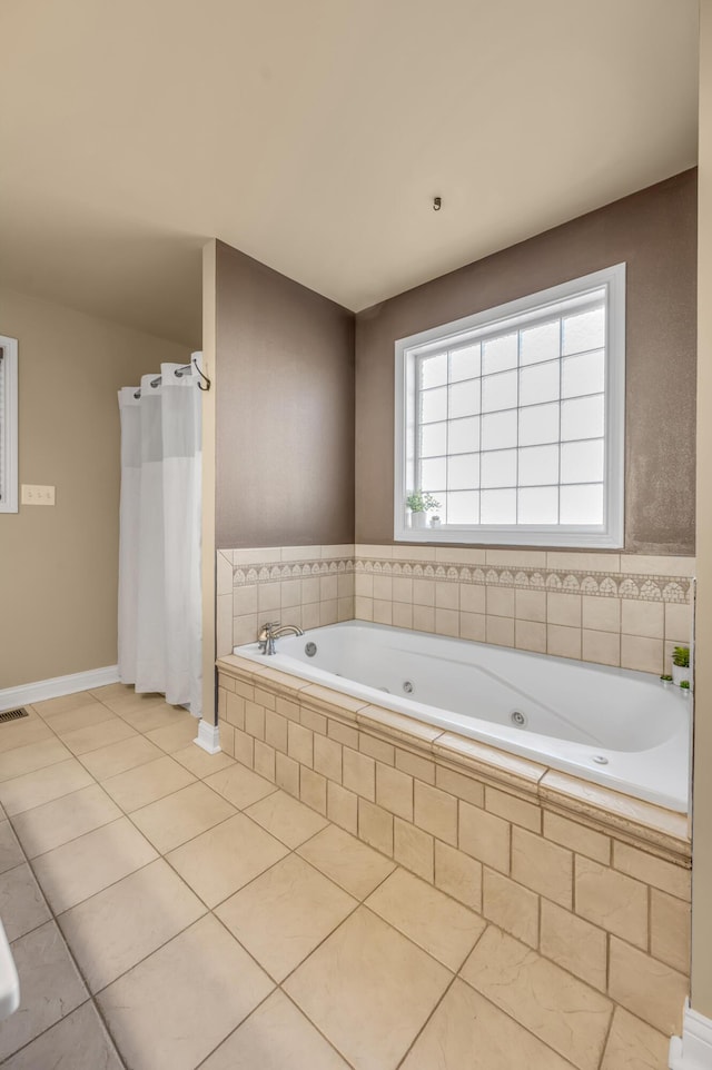 full bath with tile patterned flooring, a tub with jets, and baseboards