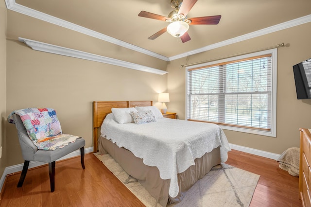 bedroom featuring ceiling fan, ornamental molding, wood finished floors, and baseboards