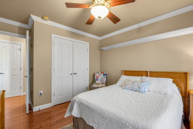 bedroom with ornamental molding, a ceiling fan, a closet, and wood finished floors