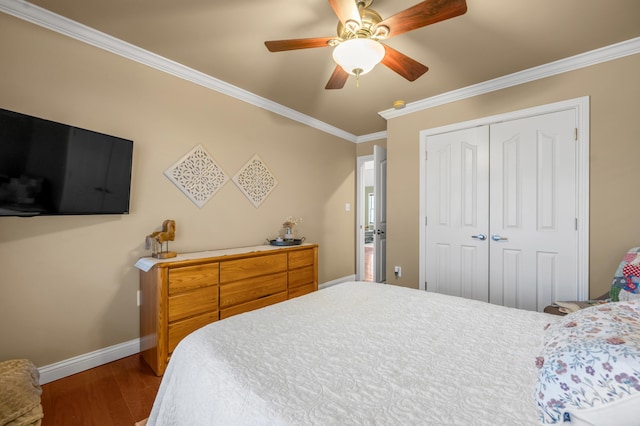 bedroom with baseboards, ceiling fan, ornamental molding, wood finished floors, and a closet