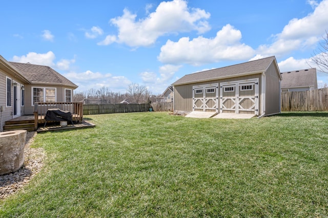 view of yard with a fenced backyard, an outdoor structure, a deck, and a storage unit