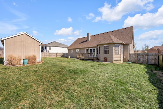 back of house with a chimney, a fenced backyard, a yard, and a deck