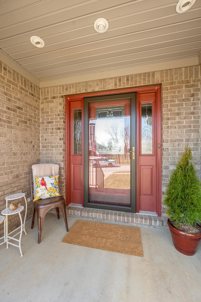 view of exterior entry featuring brick siding