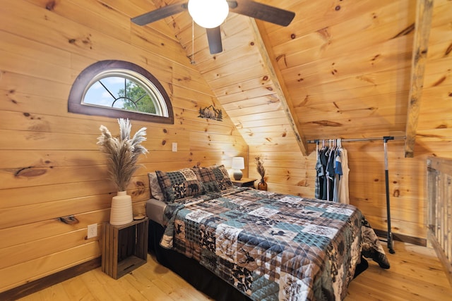 bedroom featuring wooden walls, a ceiling fan, lofted ceiling, wood ceiling, and light wood-type flooring