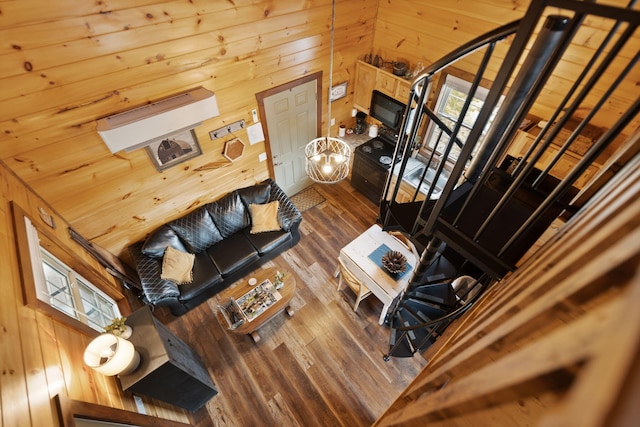 living area with dark wood-style floors and wooden walls