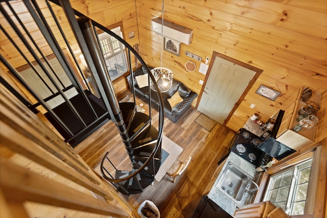 stairs featuring wooden walls and wood finished floors