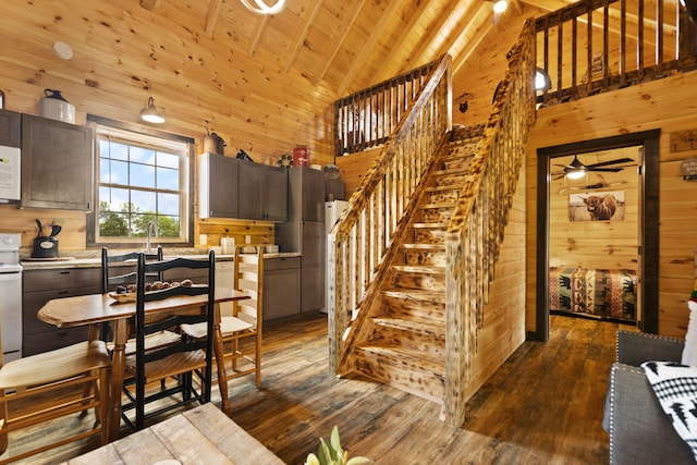 interior space with dark wood finished floors, wooden walls, wood ceiling, and high vaulted ceiling