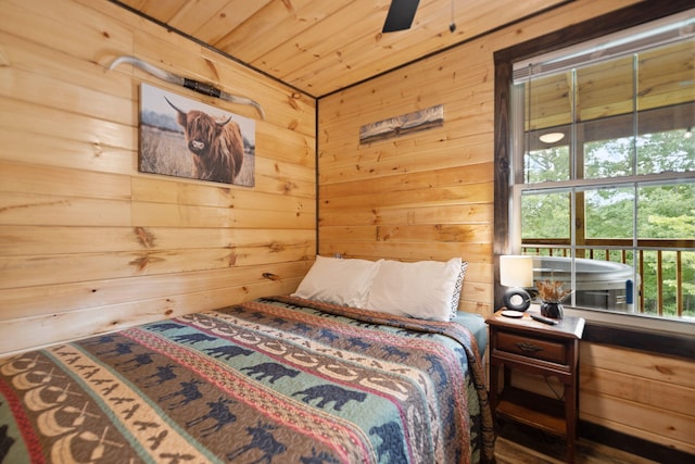 bedroom with wooden ceiling and wooden walls