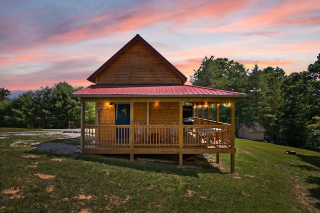 view of front facade with an outbuilding, metal roof, and a front yard