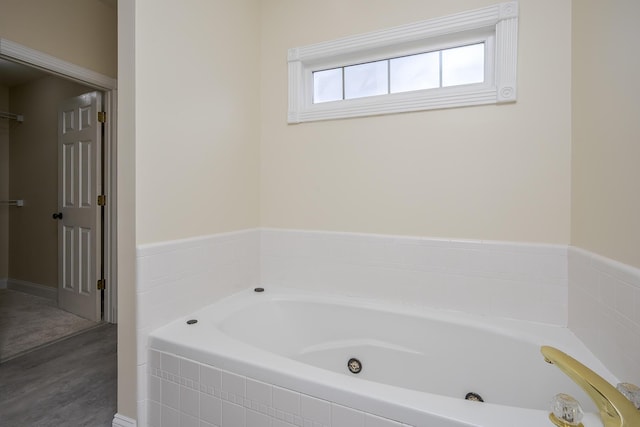 full bathroom featuring a whirlpool tub and wood finished floors