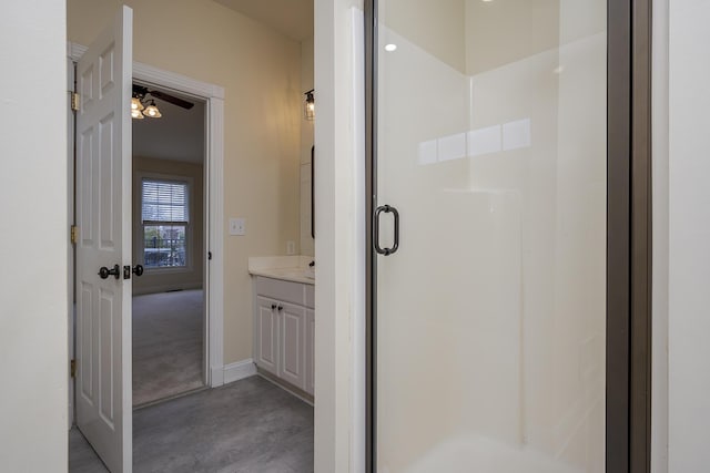 bathroom with a stall shower, baseboards, and vanity