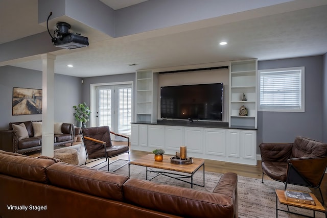 living area with light wood-style floors, recessed lighting, and ornate columns