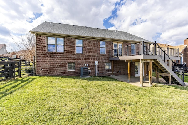 rear view of house featuring a patio area, brick siding, a lawn, and fence