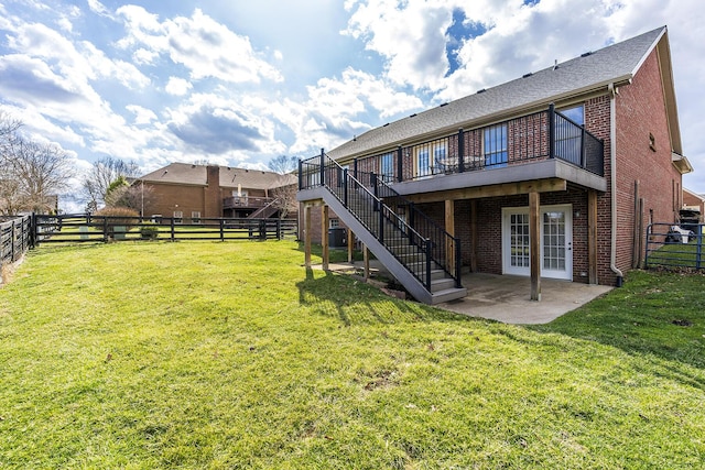 back of property featuring a patio area, stairs, a lawn, and brick siding