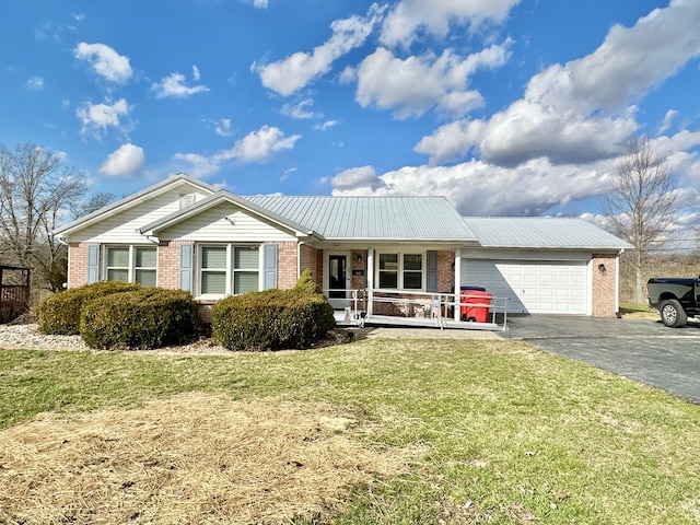 single story home with a porch, aphalt driveway, a garage, brick siding, and a front yard