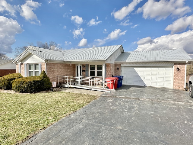 ranch-style home with brick siding, a porch, a garage, driveway, and a front lawn