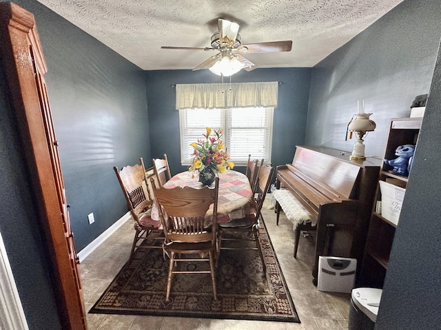 dining area with a ceiling fan, a textured ceiling, and baseboards