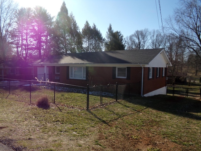 view of side of home featuring brick siding, a lawn, and fence private yard