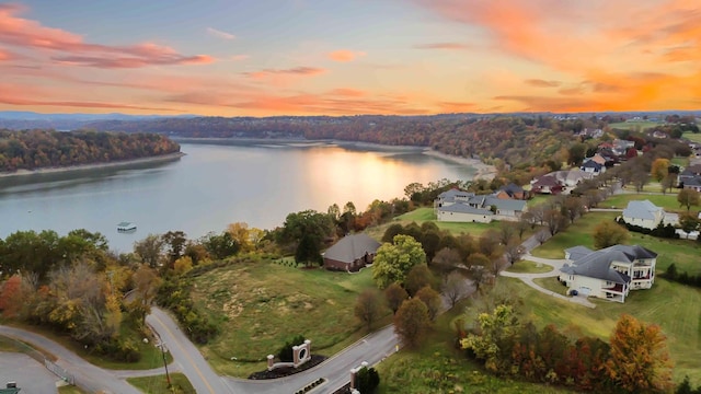 aerial view at dusk featuring a water view