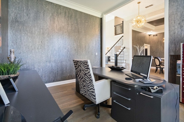 home office featuring a notable chandelier, wood finished floors, visible vents, baseboards, and ornamental molding