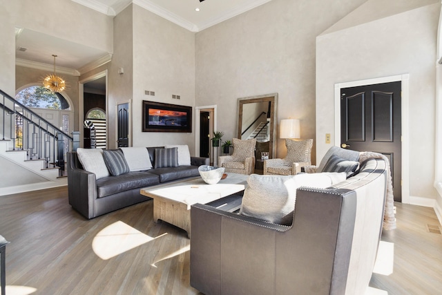 living area featuring baseboards, stairway, wood finished floors, and ornamental molding