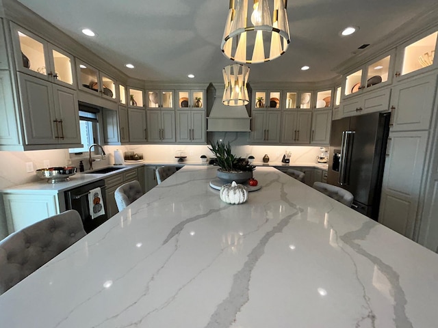 kitchen featuring recessed lighting, premium range hood, a sink, black appliances, and decorative light fixtures