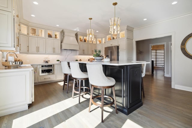 kitchen featuring stainless steel appliances, tasteful backsplash, light countertops, a sink, and premium range hood