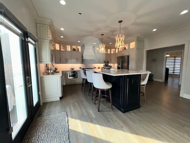 kitchen with light wood finished floors, premium range hood, black refrigerator with ice dispenser, and a wealth of natural light