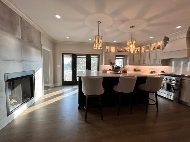 kitchen featuring dark wood finished floors, ornamental molding, stainless steel stove, a fireplace, and backsplash